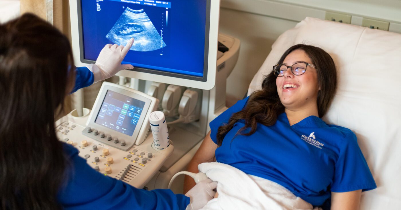 A student in the Kettering College Sonography program works in a lab with her peers on an ultrasound machine.