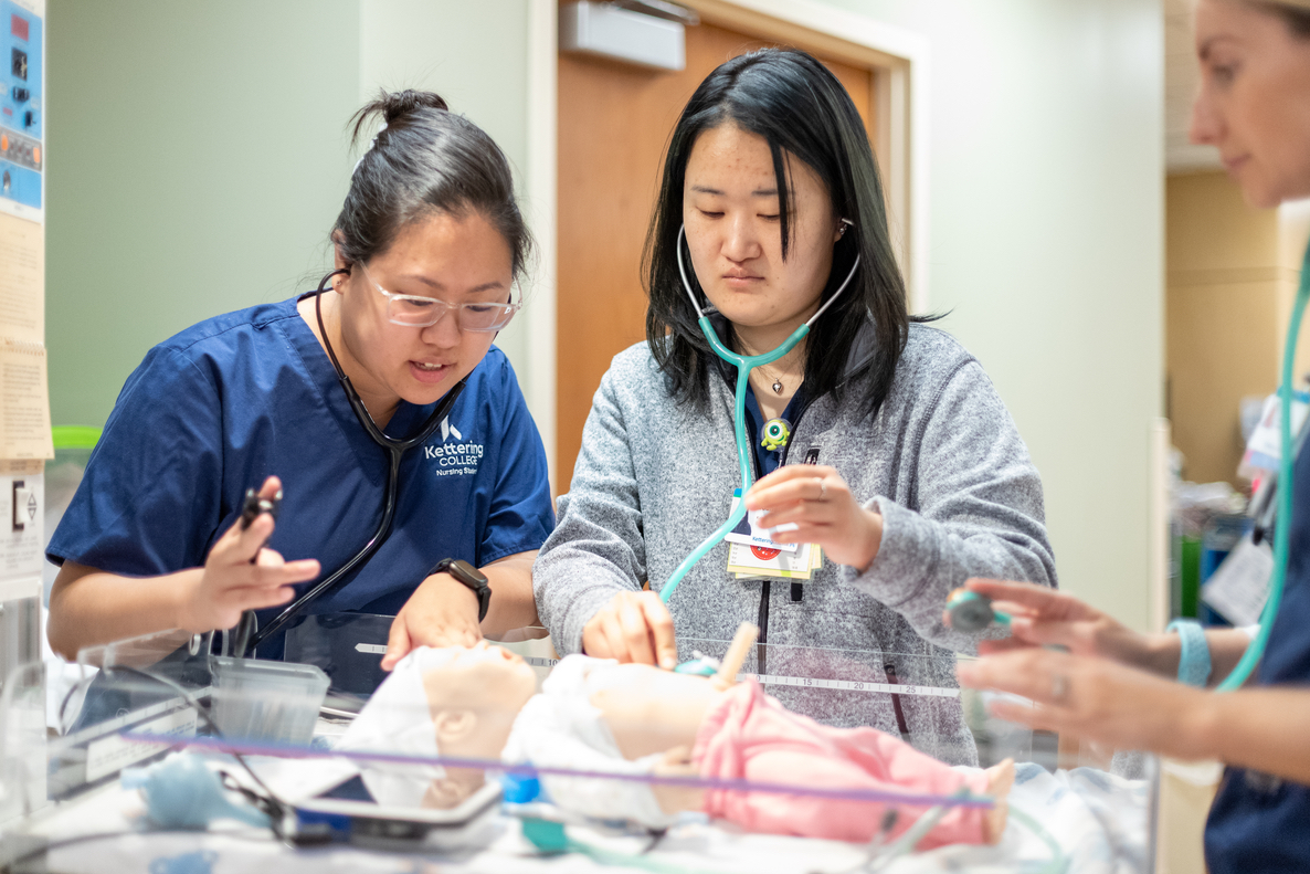 Kettering College Nursing students in the accelerated (A-BSN) program take vital signs on a mock patient in the simulation lab.